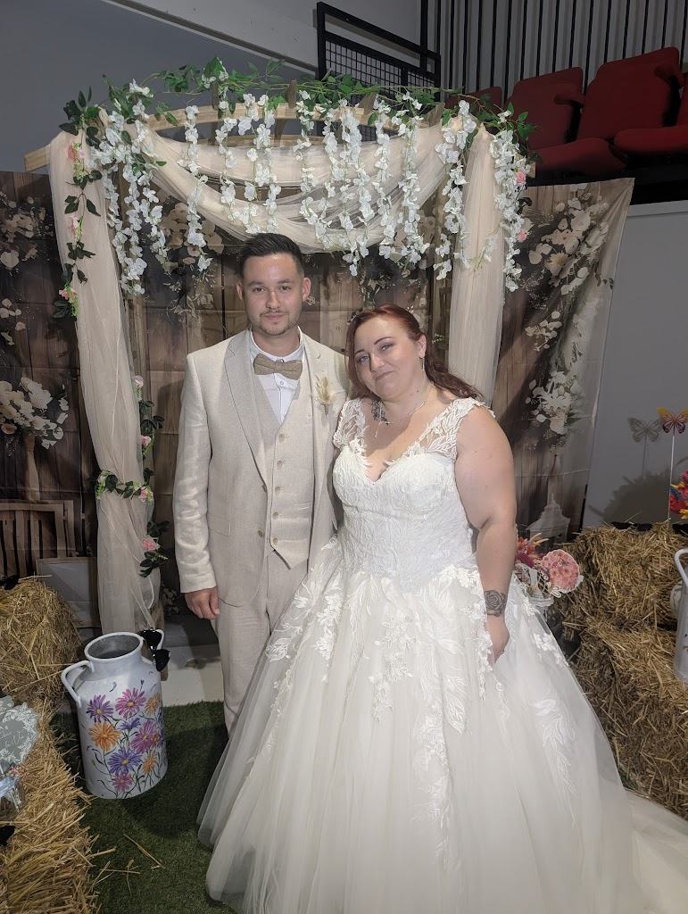 Mariage à Rochefort : les mariés sous l'arche fleurie, décor champêtre